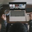 一个亚洲中国男性工作在家里使用笔记本电脑视频会议电话会议与耳机股票照片